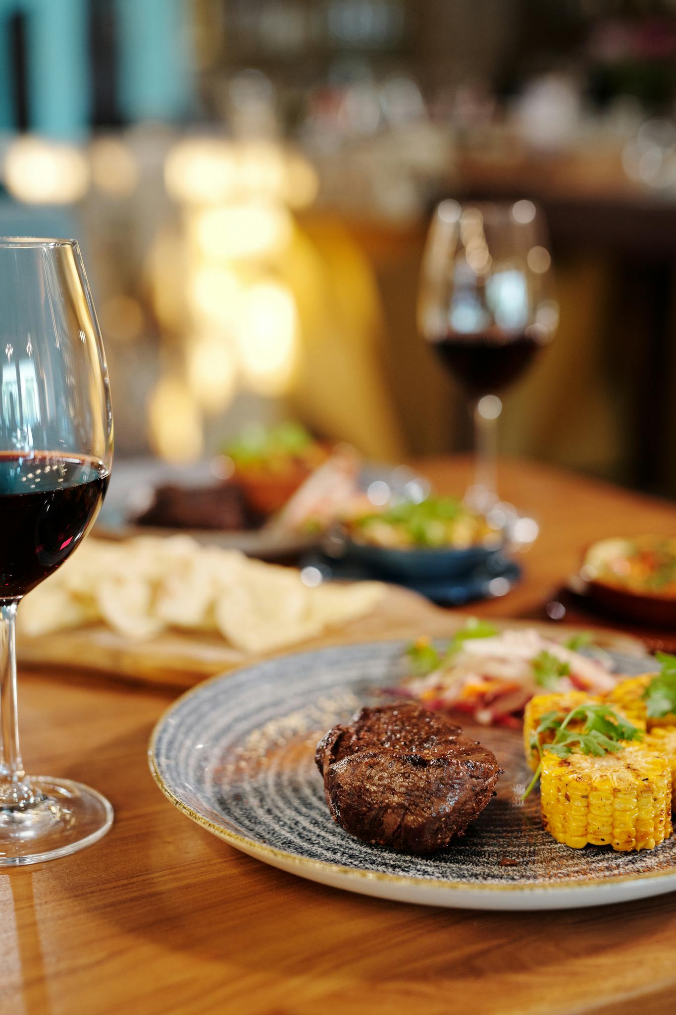 A gourmet steak dinner served with wine in a restaurant setting, capturing an elegant dining experience.